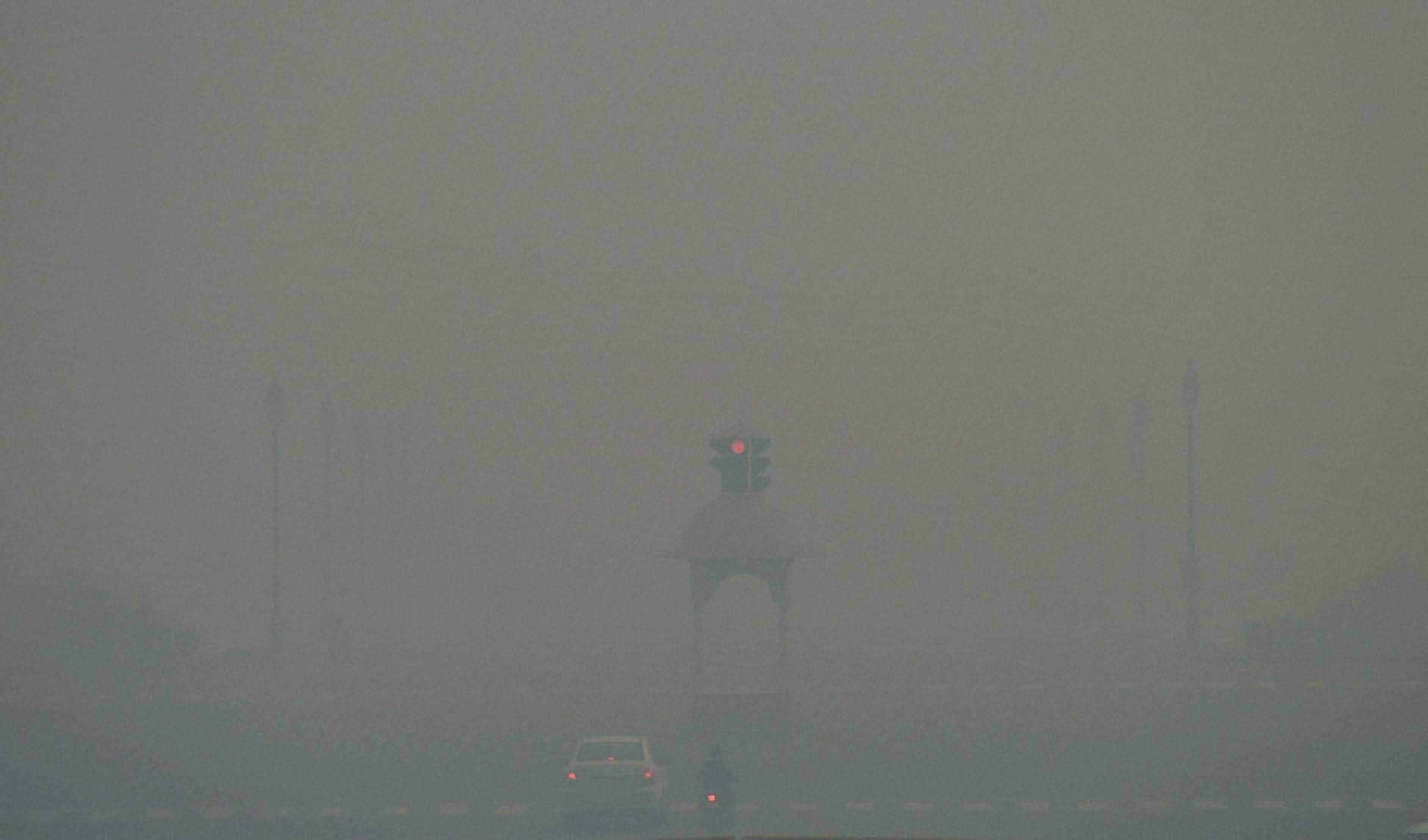 New Delhi: Vehicles ply at Rajpath as smog covers it in New Delhi on Monday morning, a day after Diwali. (Source: PTI)